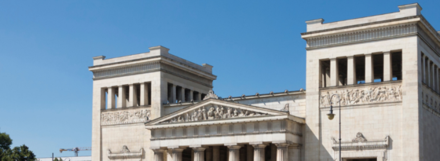 Klassizistisches Gebäude mit Säulen und Reliefs unter blauem Himmel.
