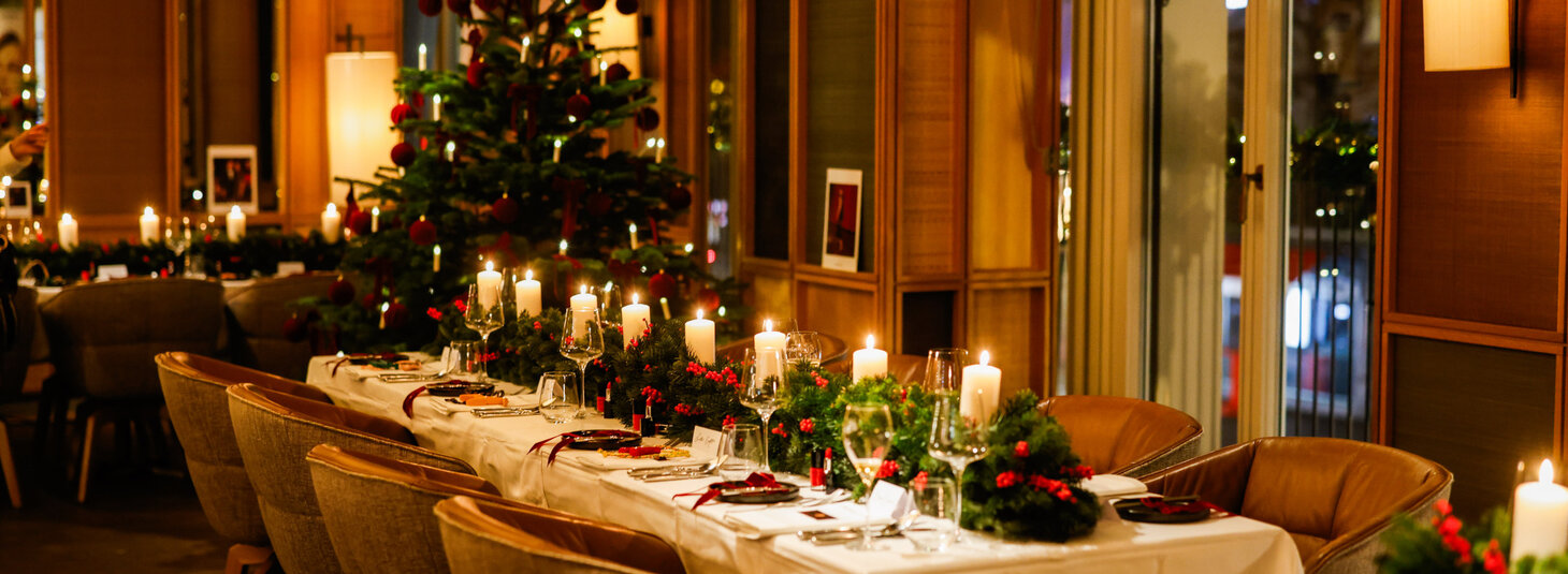 Eine festlich geschmückter Tisch steht im Restaurant Grillroom, im Hintergrund steht ein Tannenbaum.