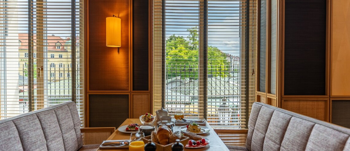 Gemütlicher Frühstückstisch im LOUIS Hotel München mit Blick auf den Viktualienmarkt.