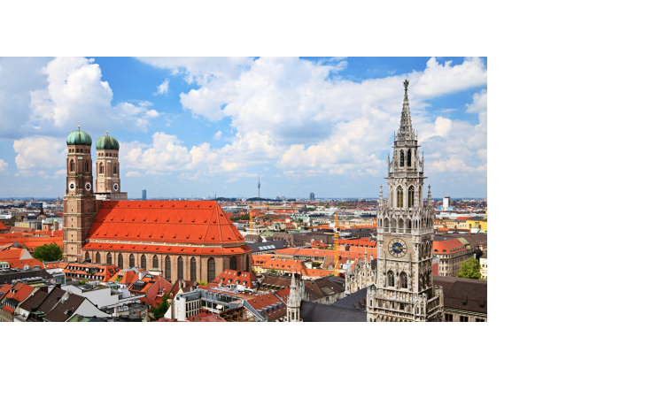 Blick über München mit Frauenkirche und Neuem Rathaus unter blauem Himmel.