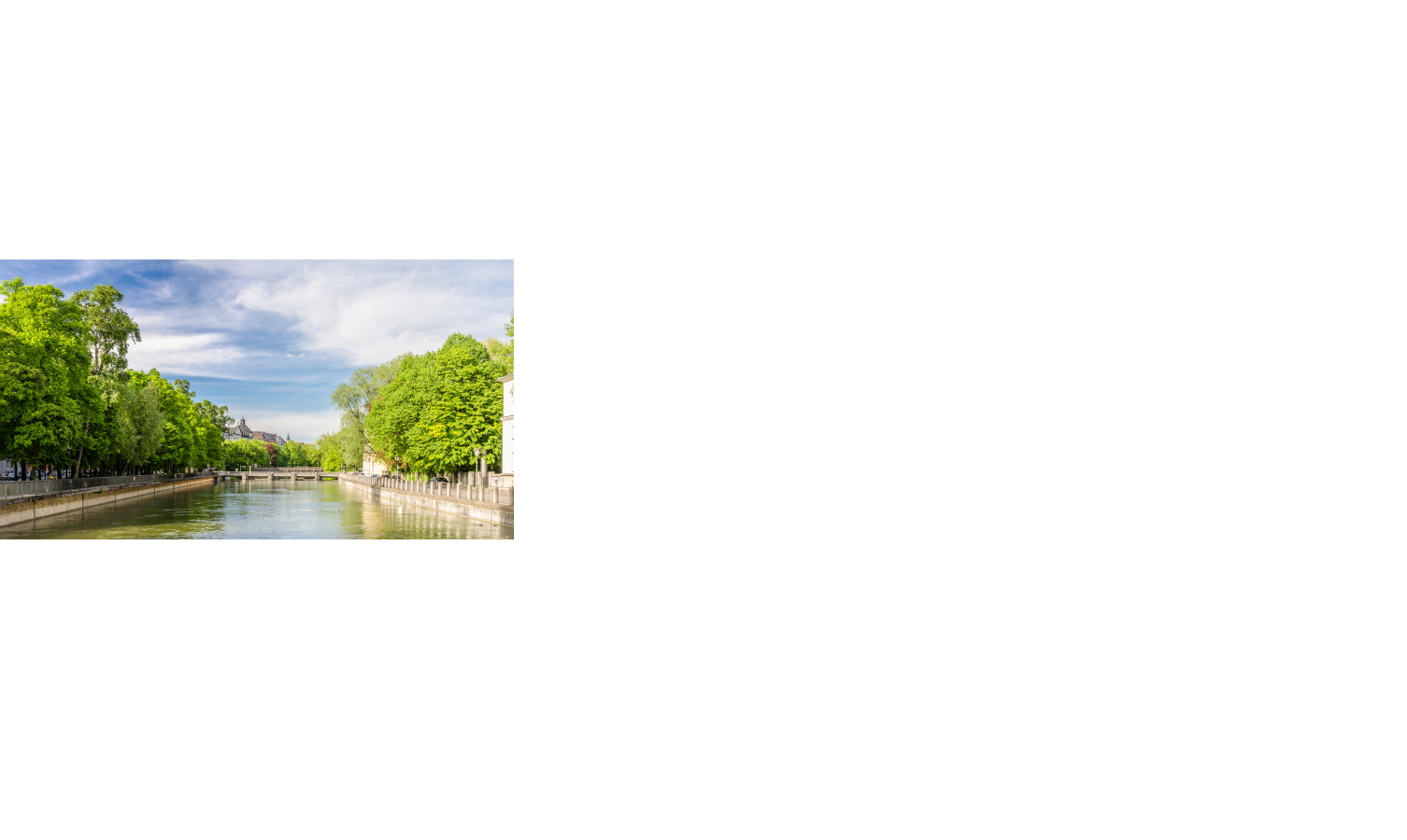 Fluss mit grünen Bäumen an den Ufern, Brücke im Hintergrund, unter blauem Himmel.