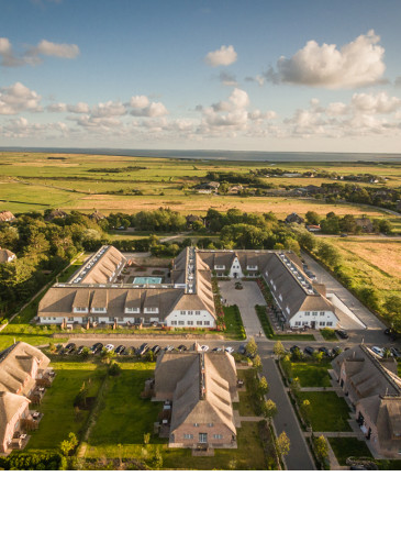 Aerial view of the Severin*s Resort & Spa on Sylt, surrounded by green countryside and picturesque skies.