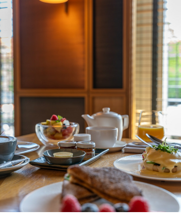 Breakfast table at the LOUIS Hotel Munich with pastries, fruit, tea and juice in an elegant ambience.
