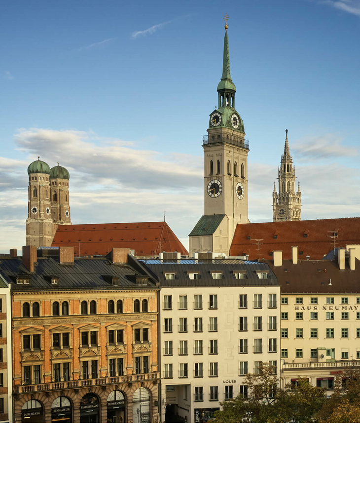 Blick auf Münchens Altstadt mit historischen Türmen und Gebäuden bei klarem Himmel.
